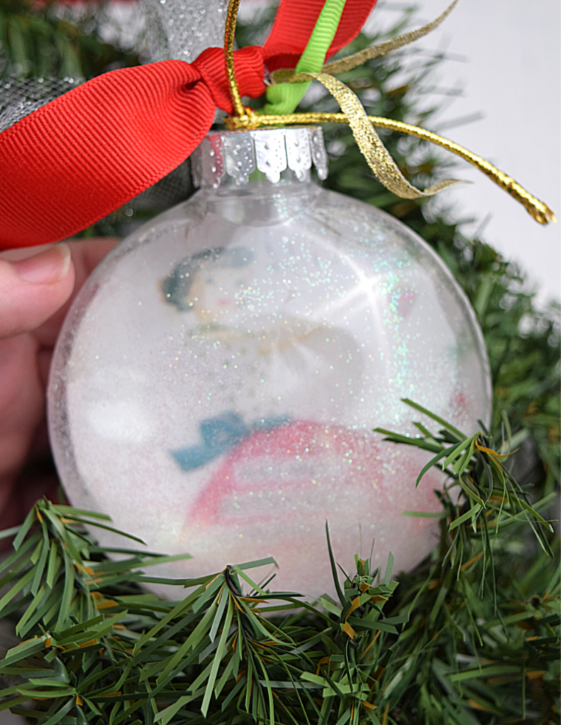 A Retro Meme Christmas Ornament that is covered in glitter and hard to see. 