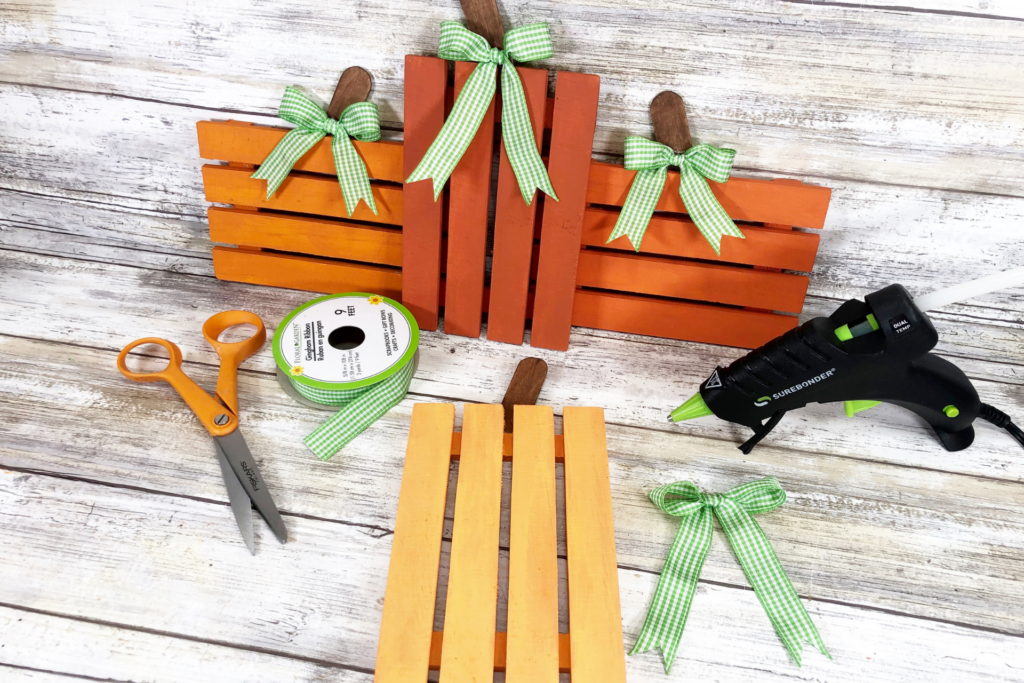 Adding the green gingham ribbon to the mini wooden pallet pumpkings