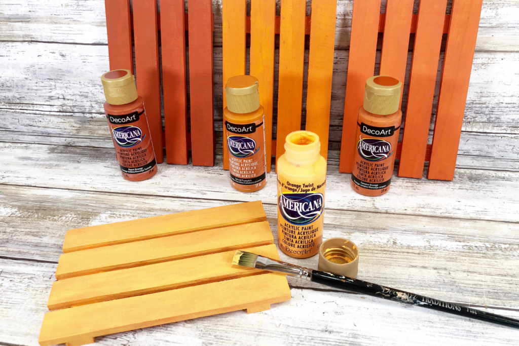 Painting a mini pallet to turn it into a diy pumpkin